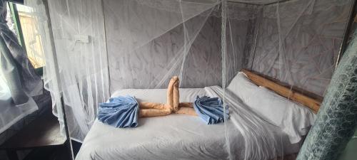 een geïmproviseerd bed in een tent met blauwe lakens bij Mambo Game View in Elmenteita