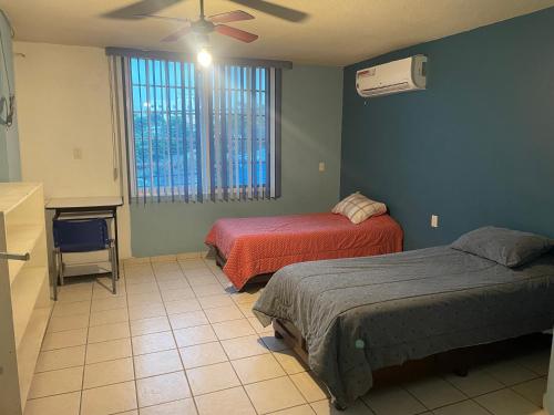 1 dormitorio con 2 camas y ventilador de techo en Departamentos grandes y centricos., en Poza Rica de Hidalgo