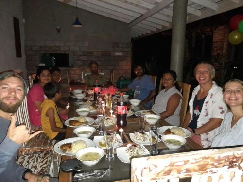 a group of people sitting around a table with food at Villa Ali in Galle