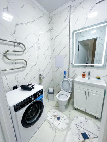 Baño blanco con aseo y lavamanos en Сдам однокомнатную квартиру по Туран 55/6, en Taldykolʼ