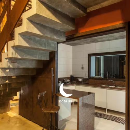 a kitchen with a staircase and a sink and a counter at Casa da Mata - Sao Jorge GO in Sao Jorge