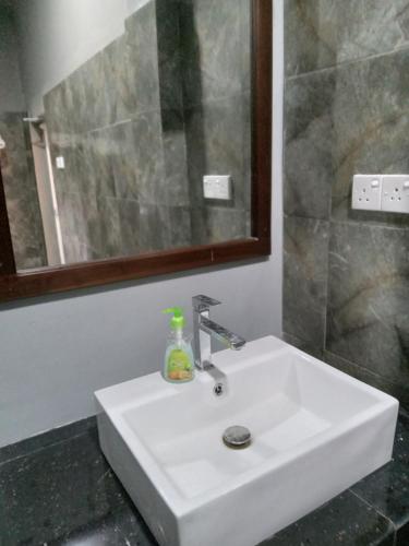 a white sink in a bathroom with a mirror at elephant eye safari house in Udawalawe