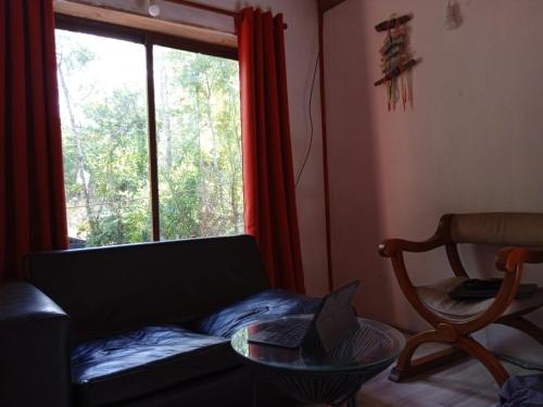 sala de estar con sofá y ventana en Cabañas Rústicas Pucon, en Pucón