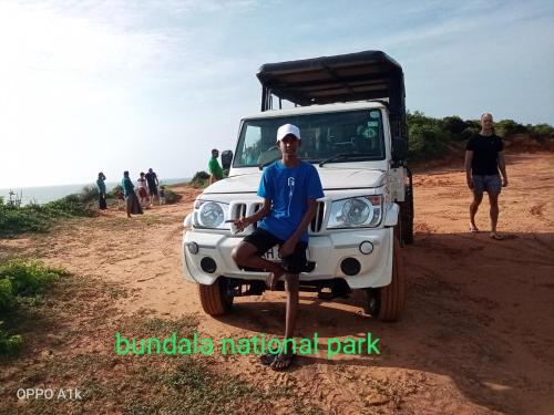 a man sitting on the front of a white truck at Green House Yala in Kirinda