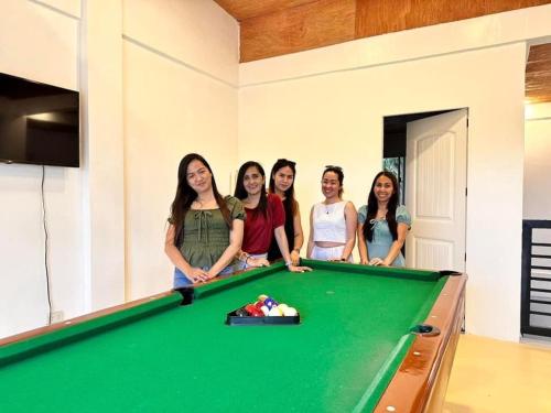 a group of women standing next to a pool table at Bahai ni Jhane in Calatagan