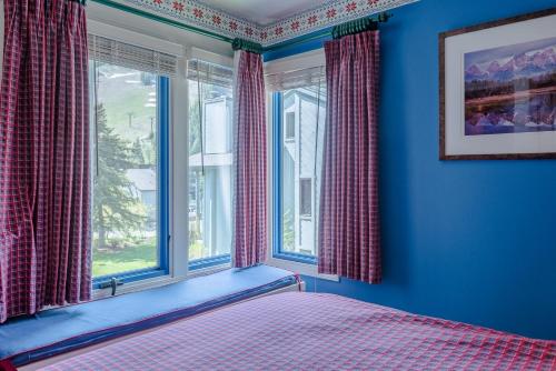 una camera da letto con pareti blu e un letto con finestre di Greyhawk Condo 10 - Great Location Close to Bald Mt Hiking and Skiing a Ketchum