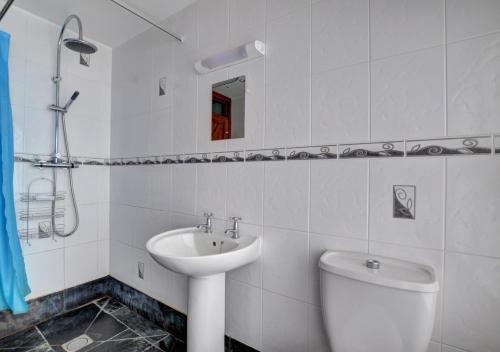 a white bathroom with a sink and a toilet at Barn 1 in Berriew