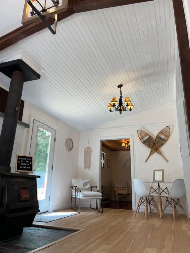 a living room with a wood stove and a ceiling at Chalet 86 - 3 Minutes From Whiteface Mountain in Wilmington