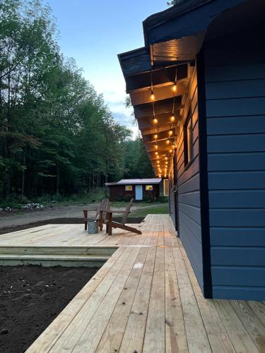 a wooden deck with a bench on the side of a house at Chalet 86 - 3 Minutes From Whiteface Mountain in Wilmington