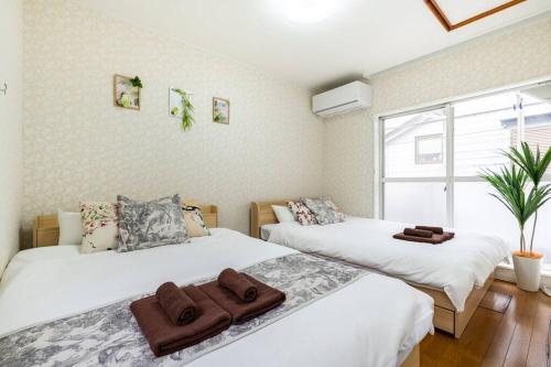 1 dormitorio con 2 camas y ventana en アンドステイ柴又5丁目B, en Tokio