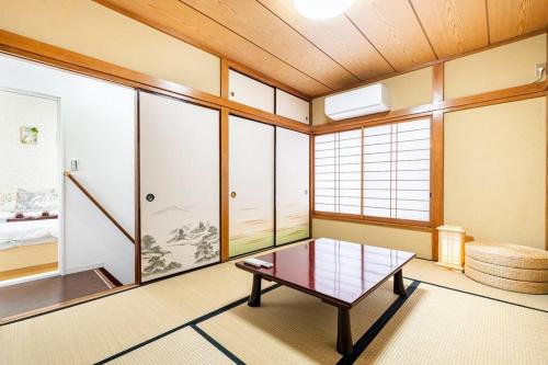 a room with a table in a room with windows at アンドステイ柴又5丁目B in Tokyo