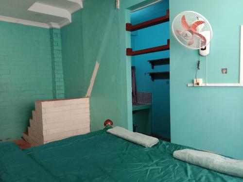 a hospital room with a bed and a fan at Kep Family House & Restaurant in Phumĭ Ŏng Char