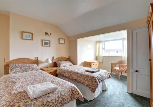 una habitación de hotel con 2 camas y una silla en Norbury, en Penmaen-mawr