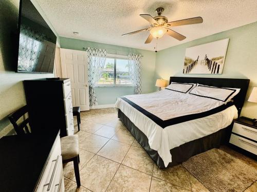a bedroom with a bed and a ceiling fan at Fun In The Sun: Canal Access in Cape Coral