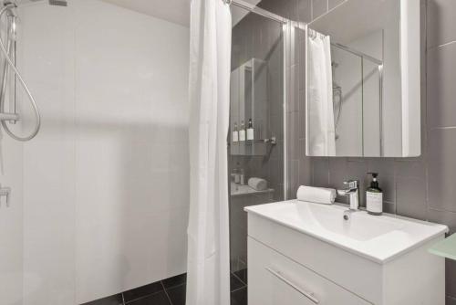 bagno bianco con lavandino e doccia di South Brisbane One Bedroom Apartment a Brisbane