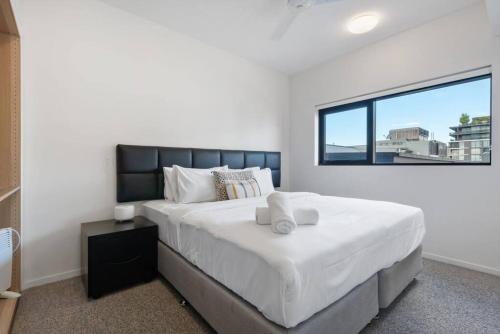 una camera con un grande letto e una grande finestra di South Brisbane One Bedroom Apartment a Brisbane