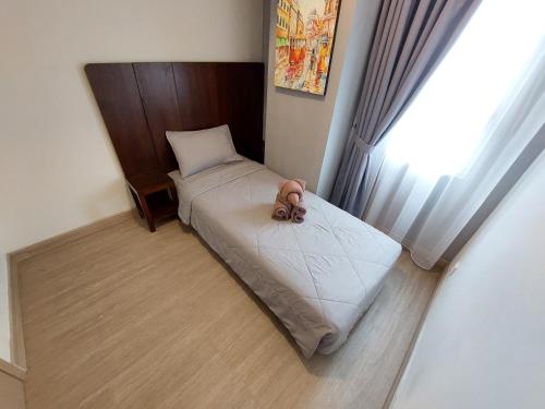 a small bed in a room with a window at Sienna Residence Bogor in Kedungbadak