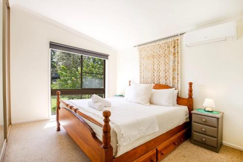 a bedroom with a large bed and a window at Annabel's Place - Pet Friendly with Fireplace in Vincentia