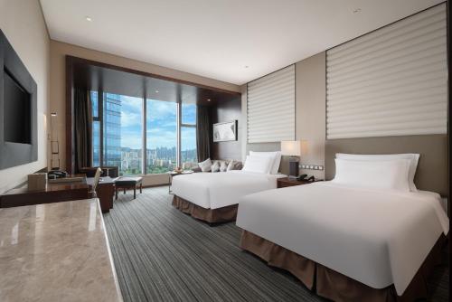 a hotel room with two beds and a large window at Radisson Blu Plaza Chongqing - Free one cup of smoky the gelnlivet during stay in Chongqing