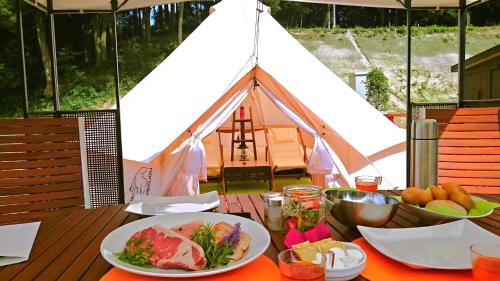 un tavolo con piatti e una tenda di THE FARM Resort Japan a Katori