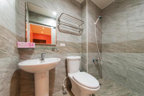 a bathroom with a toilet and a sink at 鬆宿民宿 in Luodong