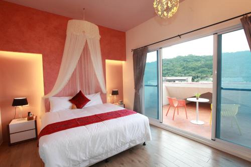 a bedroom with a bed and a large window at 坡岸長堤民宿 Leveeside House in Hualien City