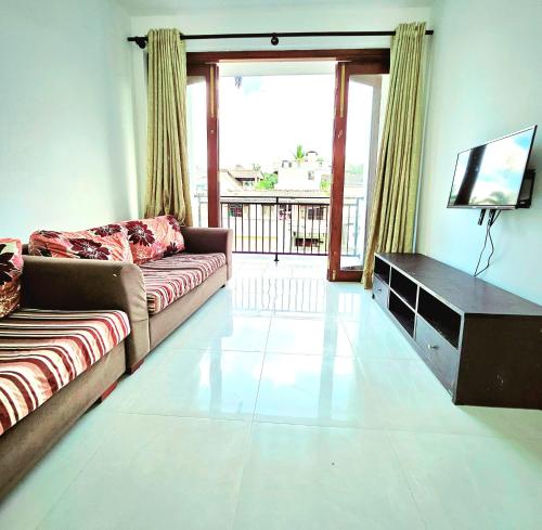 a living room with a couch and a television at Villa 005 in Kirillapone