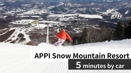 a person is skiing down a snow covered mountain at Apikogen Mori no Hotel in Hachimantai