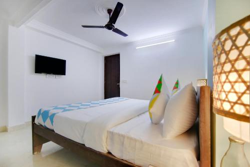 a bedroom with a bed with a ceiling fan at Flagship Khanpur STAY in New Delhi