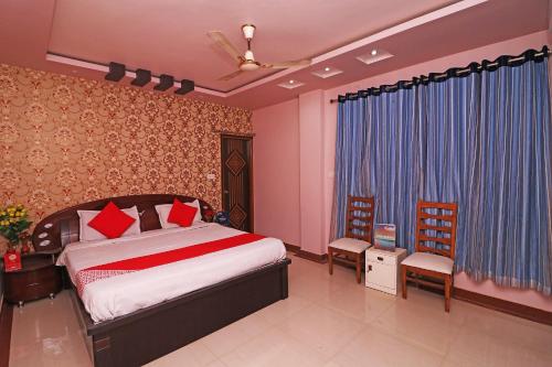 um quarto com uma cama e duas cadeiras em Collection O Shivanya Guest House em Kakarmatha