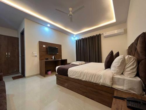 ein Schlafzimmer mit einem großen Bett und einem TV in der Unterkunft OYO The Royal Empire in Agra