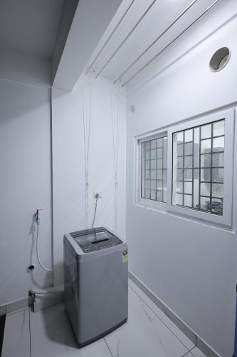 een witte kamer met een toilet en een raam bij INDIGO PALMS in Trivandrum