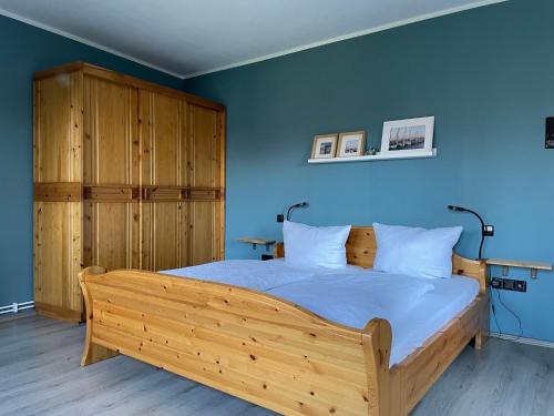 1 dormitorio con cama de madera y pared azul en Ferienwohnung Hohensee EG, en Clausthal-Zellerfeld