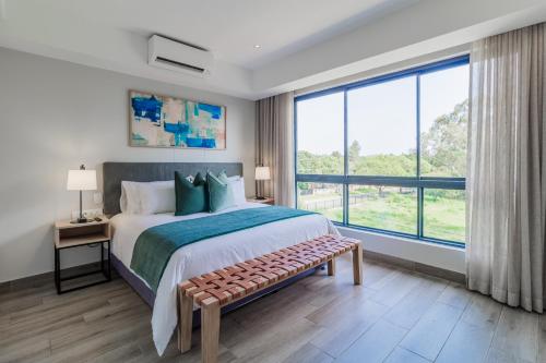 een slaapkamer met een groot bed en een groot raam bij Stay Regency Menlyn in Pretoria