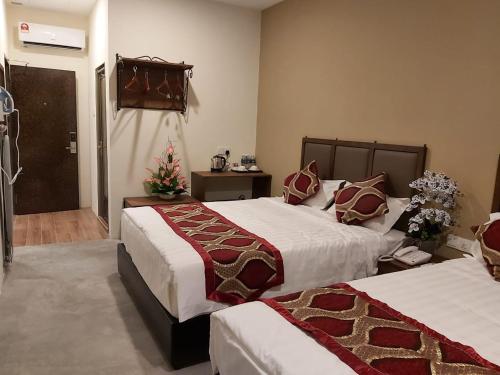 una habitación de hotel con 2 camas y una puerta en KB HOTEL, en Kepala Batas