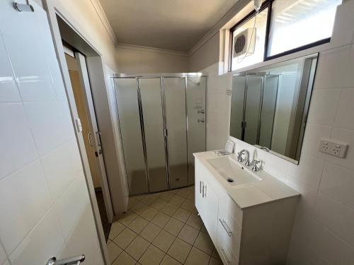 ein Bad mit einem Waschbecken und einem Spiegel in der Unterkunft Highway One Motel in Ceduna