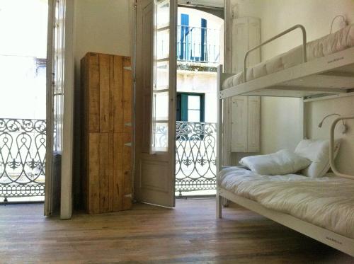 a bedroom with a bunk bed and a balcony at Slow City Hostel Pontevedra in Pontevedra