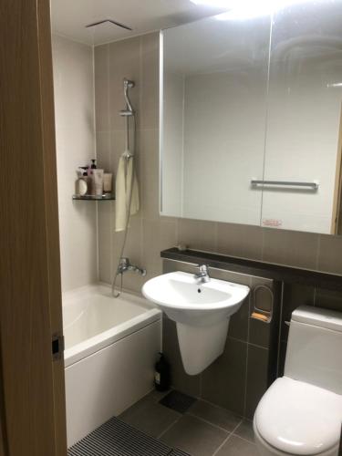 La salle de bains est pourvue d'un lavabo, de toilettes et d'une baignoire. dans l'établissement Bluepant's homestay, à Namyangju