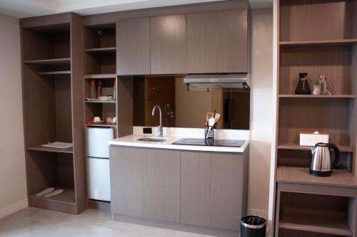 a kitchen with brown cabinets and a sink at Hayat Sky Towers Service Apartment in Cebu City