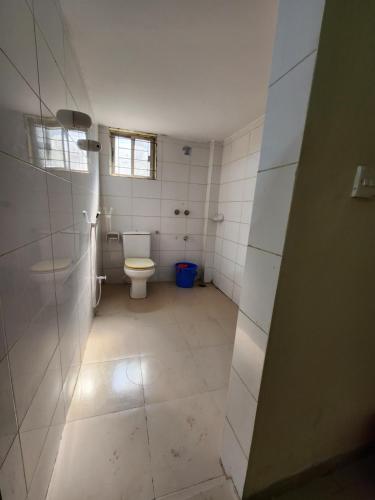 a bathroom with a toilet and a window at Aaira manjil1 in Dhaka