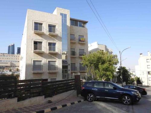 a blue car parked in front of a building at Spectacular 2 BR Apt in Jabal Amman 4th circle in Amman