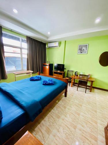 um quarto com uma cama azul e uma sala de estar em BT hotel Kata Beach em Praia de Kata