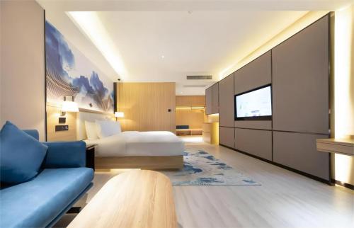 a hotel room with a bed and a tv at Ausotel by Argyle Baiyun International Airport Renhe Metro Exit B in Guangzhou