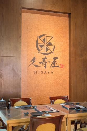 a table with chairs and a sign on a wall at Stella Di Mare Dubai Marina Hotel in Dubai