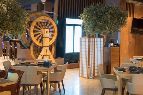 a restaurant with tables and chairs and a large wheel at Stella Di Mare Dubai Marina Hotel in Dubai