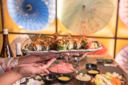 a person is holding a plate of food at Stella Di Mare Dubai Marina Hotel in Dubai