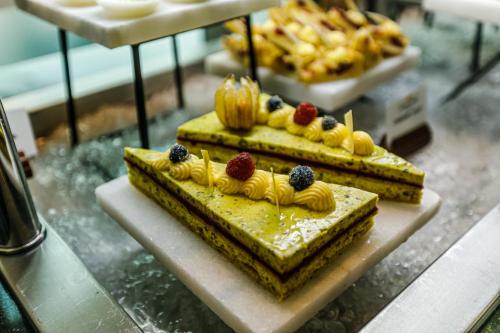 two cakes with fruit on top on a counter at Stella Di Mare Dubai Marina Hotel in Dubai