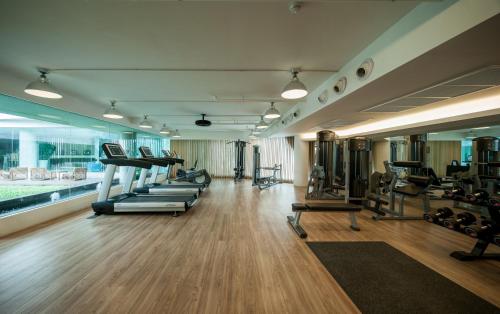 un gimnasio con una fila de cintas de correr y máquinas en LiT BANGKOK Hotel - SHA Extra Plus, en Bangkok