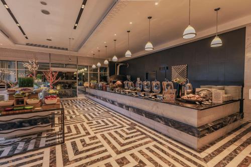 a restaurant with a counter with food on it at Stella Di Mare Dubai Marina Hotel in Dubai