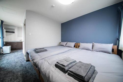 ein Schlafzimmer mit einem großen Bett mit Handtüchern darauf in der Unterkunft THE NORTH PEAK 104 in Furano